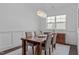 Elegant dining room featuring a modern chandelier, wainscoting, and a large window at 236 Lucky Ribbon Ln, Holly Springs, NC 27540