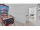 Hallway leading to the living room features light carpet, neutral colors, and a pinball machine at 236 Lucky Ribbon Ln, Holly Springs, NC 27540