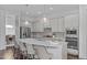 Stylish kitchen with gray cabinets, modern appliances, a large island and bar stool seating at 236 Lucky Ribbon Ln, Holly Springs, NC 27540