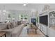 Bright living room boasts a fireplace, TV console and access to outdoor living at 236 Lucky Ribbon Ln, Holly Springs, NC 27540