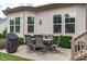 Cozy outdoor dining area features a stone patio with an outdoor dining table and grill with backyard access at 236 Lucky Ribbon Ln, Holly Springs, NC 27540