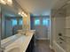 Bathroom featuring double vanity with large mirror, tiled floors, and shower/tub at 238 Alamosa Pl, Cary, NC 27519