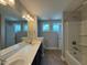 Bright bathroom featuring a double vanity, large mirror, and shower-tub combo at 238 Alamosa Pl, Cary, NC 27519