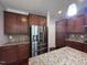 Modern kitchen with stainless steel refrigerator, granite countertops and rich wood cabinetry at 238 Alamosa Pl, Cary, NC 27519