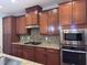 Gourmet kitchen featuring stainless steel appliances, custom backsplash and rich wood cabinetry at 238 Alamosa Pl, Cary, NC 27519