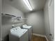 This laundry room offers a washer, dryer, and shelving for storage at 238 Alamosa Pl, Cary, NC 27519