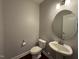 Compact powder room featuring a pedestal sink and toilet at 238 Alamosa Pl, Cary, NC 27519