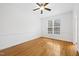Bright bedroom featuring pristine white walls, lovely hardwood floors, and a modern ceiling fan at 2418 Mont Haven Dr, Durham, NC 27712