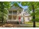 Charming two-story home boasts double front porches, a red front door, and beautifully landscaped surroundings at 2418 Mont Haven Dr, Durham, NC 27712