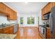Well-lit kitchen boasts stainless steel appliances, granite countertops, and hardwood floors at 2418 Mont Haven Dr, Durham, NC 27712