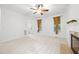 Bright living room featuring plush carpet, a cozy fireplace, and two windows adorned with elegant drapery at 2418 Mont Haven Dr, Durham, NC 27712