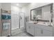 Bathroom featuring a double sink vanity, framed mirror, stylish ladder decor, and an enclosed glass door shower at 2730 Spring Valley Dr, Creedmoor, NC 27522
