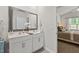 A well-lit bathroom boasts double sinks, white cabinets, a large mirror, and a glimpse of a connected bedroom at 2730 Spring Valley Dr, Creedmoor, NC 27522
