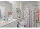 Bathroom featuring a single sink vanity, framed mirror, floral accents, and a shower-tub combo with a floral shower curtain at 2730 Spring Valley Dr, Creedmoor, NC 27522