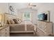 Well-lit bedroom featuring a large bed with decorative pillows, a ceiling fan, and a neutral color scheme at 2730 Spring Valley Dr, Creedmoor, NC 27522