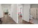 Hallway with wood floors offers views into a brightly decorated bedroom and a full bathroom with a shower and tub at 2730 Spring Valley Dr, Creedmoor, NC 27522