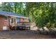 A wooden deck sits off the rear of the home, nestled in a wooded lot with a brick exterior at 2801 E Shoreham St, Durham, NC 27707