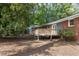 Spacious backyard featuring a wood deck, brick exterior, and lush green foliage, perfect for outdoor enjoyment at 2801 E Shoreham St, Durham, NC 27707