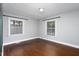 Bright bedroom with hardwood flooring, light gray walls, and two windows showcasing natural light at 2801 E Shoreham St, Durham, NC 27707