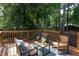 Outdoor deck setup with comfortable wicker chairs, small table, and a beautiful, private wooded backyard at 2801 E Shoreham St, Durham, NC 27707