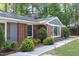 Close up of an exterior side wall of brick house, with manicured landscaping, and a sidewalk at 2801 E Shoreham St, Durham, NC 27707