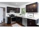 Modern kitchen with dark cabinetry, stainless steel appliances, and granite countertops at 2801 E Shoreham St, Durham, NC 27707