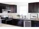 Stylish kitchen featuring dark cabinetry, stainless steel appliances, and granite countertops at 2801 E Shoreham St, Durham, NC 27707