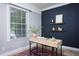 Sunlit office space with a modern desk, shelving, and a large window at 2801 E Shoreham St, Durham, NC 27707