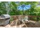 Outdoor deck with dining set and grill, perfect for entertaining in a private, wooded setting at 2925 Dargan Hills Dr, Wake Forest, NC 27587
