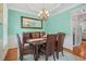 Dining room features blue walls, a wooden table, chandelier, and hardwood floors at 2925 Dargan Hills Dr, Wake Forest, NC 27587
