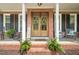 Inviting front porch with rocking chairs, ferns, and a decorative wooden front door at 2925 Dargan Hills Dr, Wake Forest, NC 27587