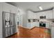 Modern kitchen with white cabinets, stainless steel appliances, and hardwood floors at 2925 Dargan Hills Dr, Wake Forest, NC 27587