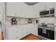 Close up of kitchen with white cabinets, granite countertops, stainless appliances, and hardwood flooring at 2925 Dargan Hills Dr, Wake Forest, NC 27587
