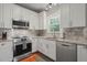 Kitchen showcasing white cabinets, stainless steel appliances, granite countertops, and natural light from the window at 2925 Dargan Hills Dr, Wake Forest, NC 27587