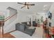 Spacious living room with hardwood floors, gray sofa, and natural light through windows at 2925 Dargan Hills Dr, Wake Forest, NC 27587