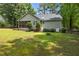 Backyard view featuring a green lawn and wooded surroundings at 296 Gordon Farm Dr, Benson, NC 27504