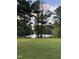 Scenic backyard view of a tranquil lake surrounded by lush trees and greenery at 296 Gordon Farm Dr, Benson, NC 27504