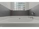 Bathroom featuring a modern soaker tub with subway tile and glass block window at 296 Gordon Farm Dr, Benson, NC 27504