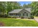 Inviting single-story home with a cozy front porch and well-maintained lawn surrounded by mature trees at 296 Gordon Farm Dr, Benson, NC 27504