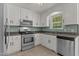 A well-lit kitchen featuring stainless steel appliances and a tiled backsplash at 296 Gordon Farm Dr, Benson, NC 27504