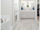 Elegant bathroom with double sinks, grey tile floors, and a walk-in shower offering spa-like comfort at 301 Porter Hill Dr, Youngsville, NC 27596