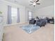 Spacious bedroom with a ceiling fan, two sitting chairs, and a comfortable bed with an ornate blue patterned rug at 301 Porter Hill Dr, Youngsville, NC 27596