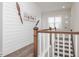 Hallway featuring unique airplane propeller decor, wood accents, and a staircase with a wooden railing and white spindles at 301 Porter Hill Dr, Youngsville, NC 27596