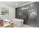 Bright bathroom with a standalone tub and glass-enclosed shower, complemented by black marble accents and modern fixtures at 3032 Dixon Rd, Durham, NC 27707