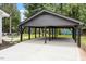 Spacious, modern carport with a gray roof, black support beams, and concrete flooring at 3032 Dixon Rd, Durham, NC 27707