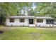 Beautifully renovated single-story home with painted white brick and professionally landscaped front yard at 3032 Dixon Rd, Durham, NC 27707