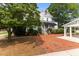 Backyard brick patio and a manicured lawn featuring mature trees for shade at 309 W Divine St, Dunn, NC 28334