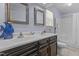 Bathroom featuring double sinks, dark wood cabinetry, and shower with glass door at 309 W Divine St, Dunn, NC 28334