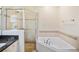Bright bathroom featuring a separate shower and soaking tub with beautiful beige tile at 315 Allister Dr, Raleigh, NC 27609
