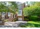 Charming brick townhome with manicured landscaping, a one-car garage, and inviting staircase leading to the front door at 315 Allister Dr, Raleigh, NC 27609